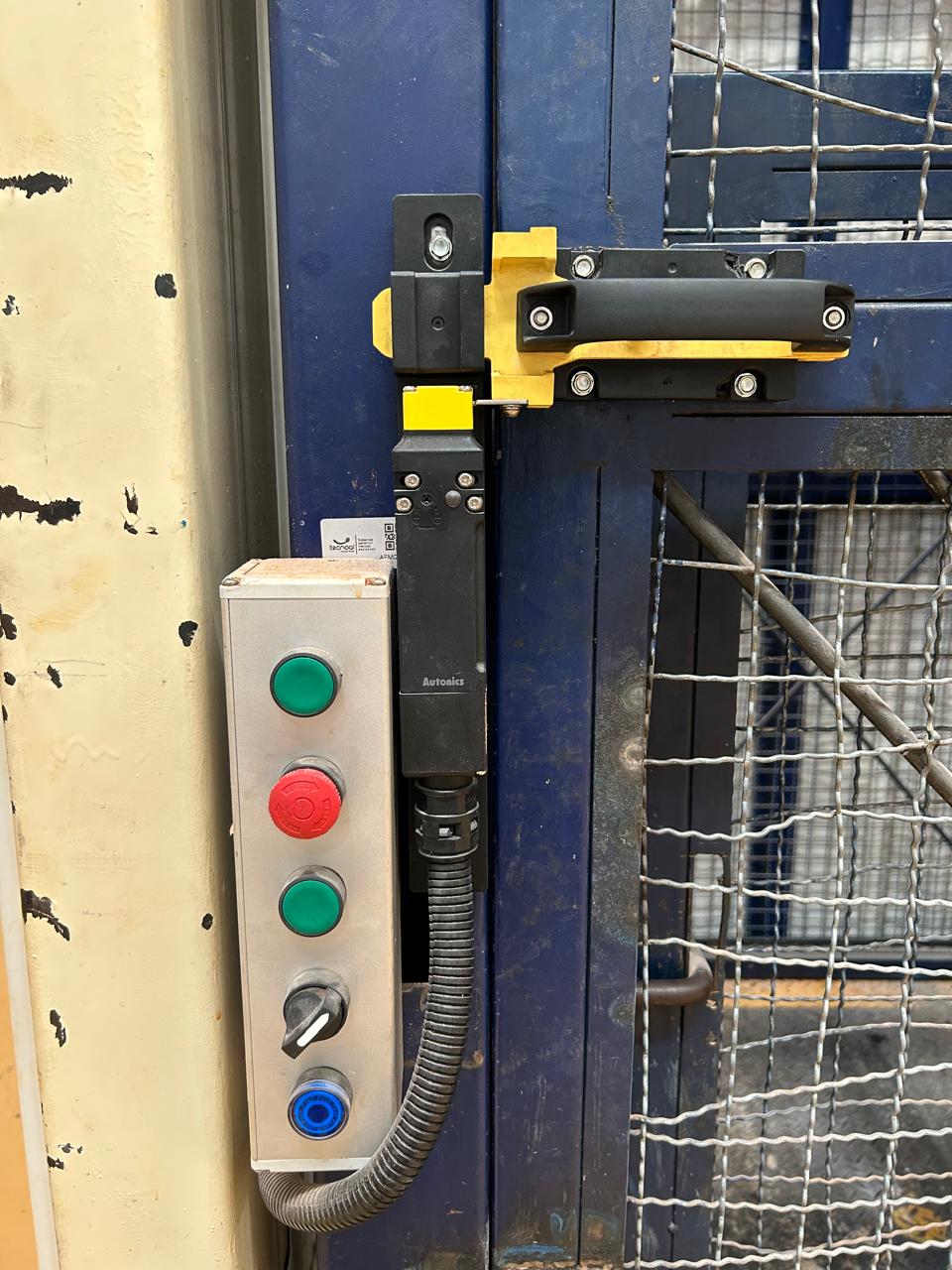 Interlock de seguridad y botonera de mando instalados en una puerta de guarda
