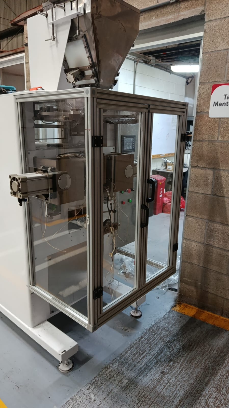 Guarda de seguridad con puertas abatibles y visores en una máquina dosificadora